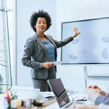 Businesswoman presenting data on screen in meeting room.