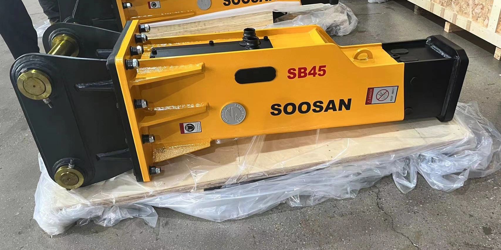 Soosan SB45 hydraulic breaker: new, packaged, industrial excavator attachment.