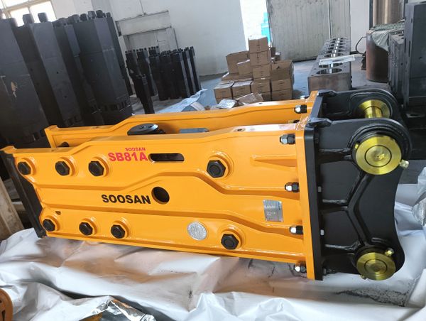 Soosan SB81A hydraulic breaker rests on protective wrapping in a workshop.