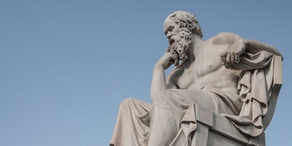 Marble statue of a seated philosopher lost in thought.