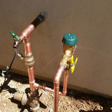 Copper pipes with valves installed against a wall.