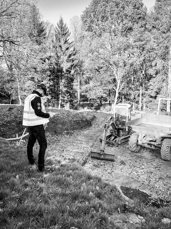 A Black and White Image of a Man With an Excavator