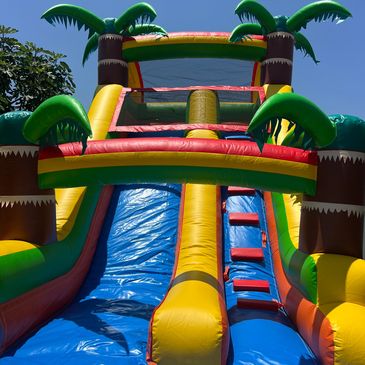 Colorful inflatable water slide under clear sky.