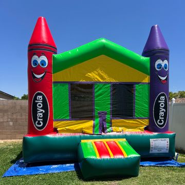 Colorful Crayola-themed inflatable bounce house in a backyard.