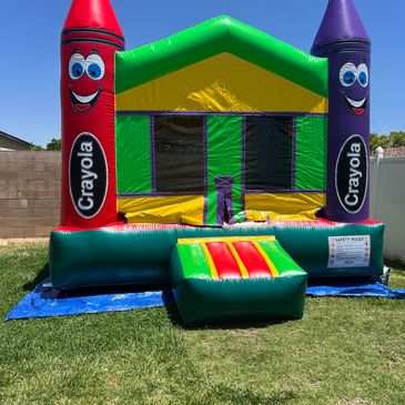 Inflatable Crayola-themed bounce house outdoors.
