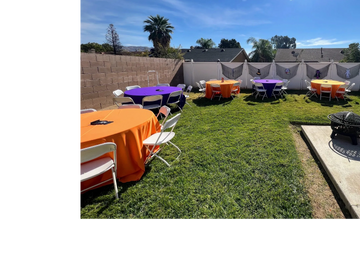 Backyard setup with colorful tables and chairs for a gathering.