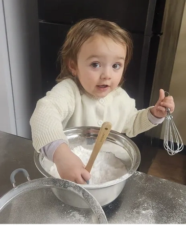 Little girl mixing flour and baking powder.