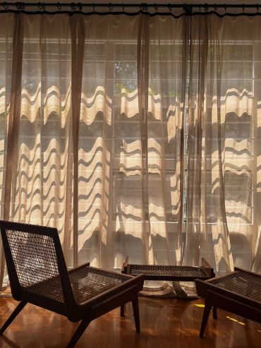 Sillones con luz suave y cortinas translúcidas.