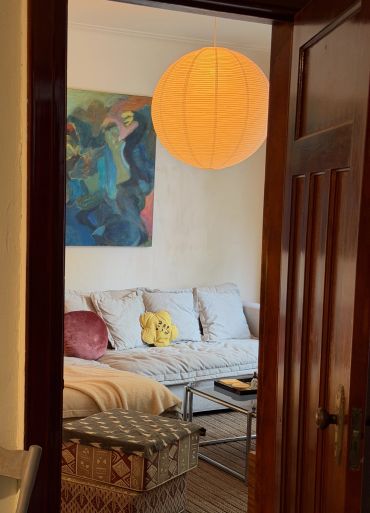 Cozy living room with soft lighting, a cushioned sofa, and artistic decor.