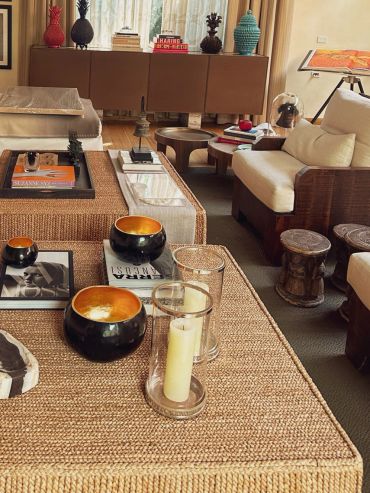 Cozy living room with woven furniture and decorative candles.
