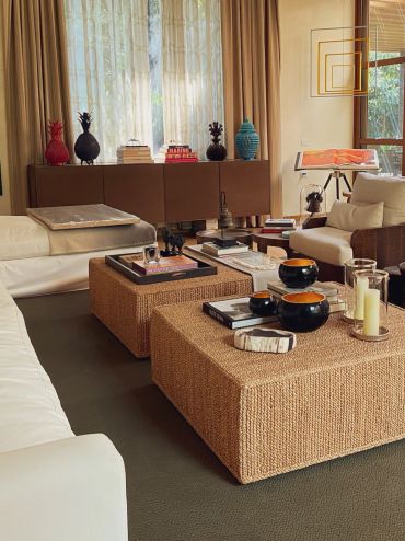Cozy living room with woven coffee tables and artistic decor accents.