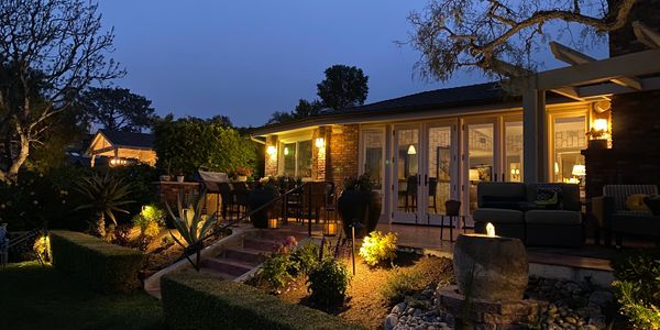 Cozy backyard patio at dusk with warm lighting.