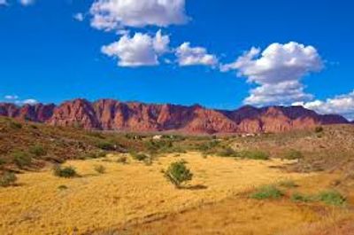 Sunny desert landscape with mountains and blue sky.
