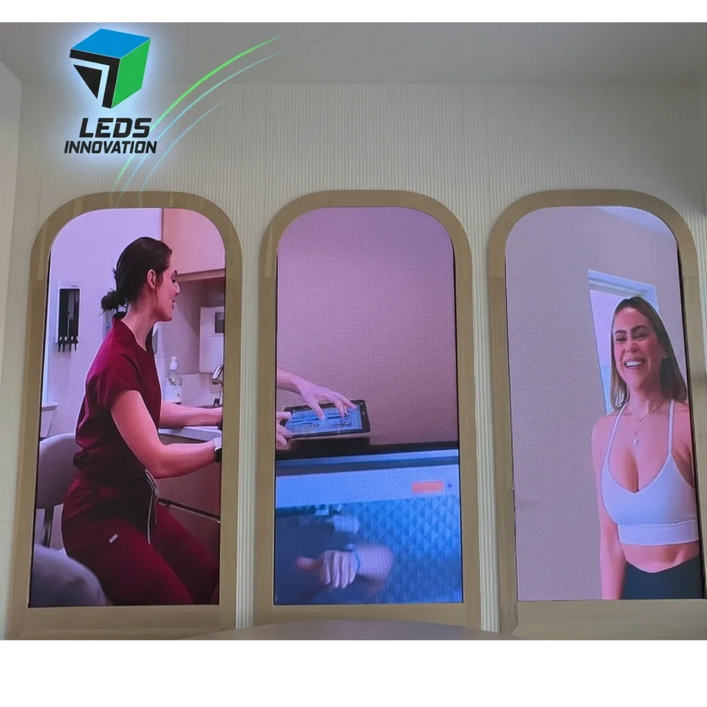 Three vertical LED screens show a woman in medical scrubs, hands with a tablet, and a smiling woman in workout attire.