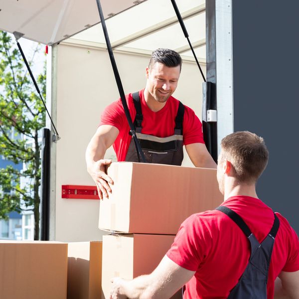 Two men moving boxes from a truck