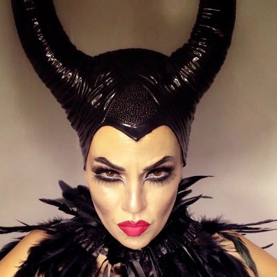 Person in Maleficent-inspired costume with horned headpiece and dramatic makeup.