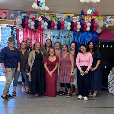 Group photo of women in a decorated room.