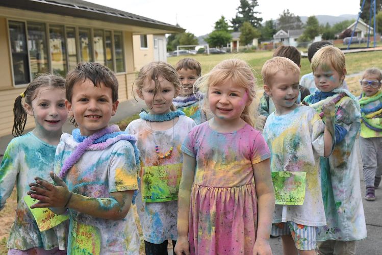 Children covered in colorful powder after a fun outdoor event.
