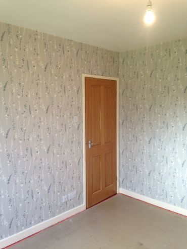 Wallpapering a bedroom in Southwold. 