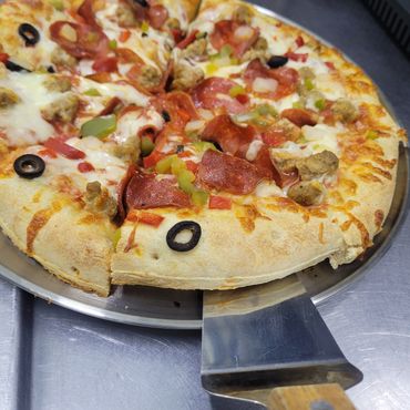 A freshly baked pizza with pepperoni, olives, and green peppers.