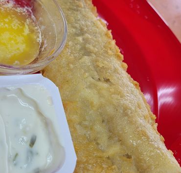 Golden fried pastry with a side of creamy sauce and melted butter.