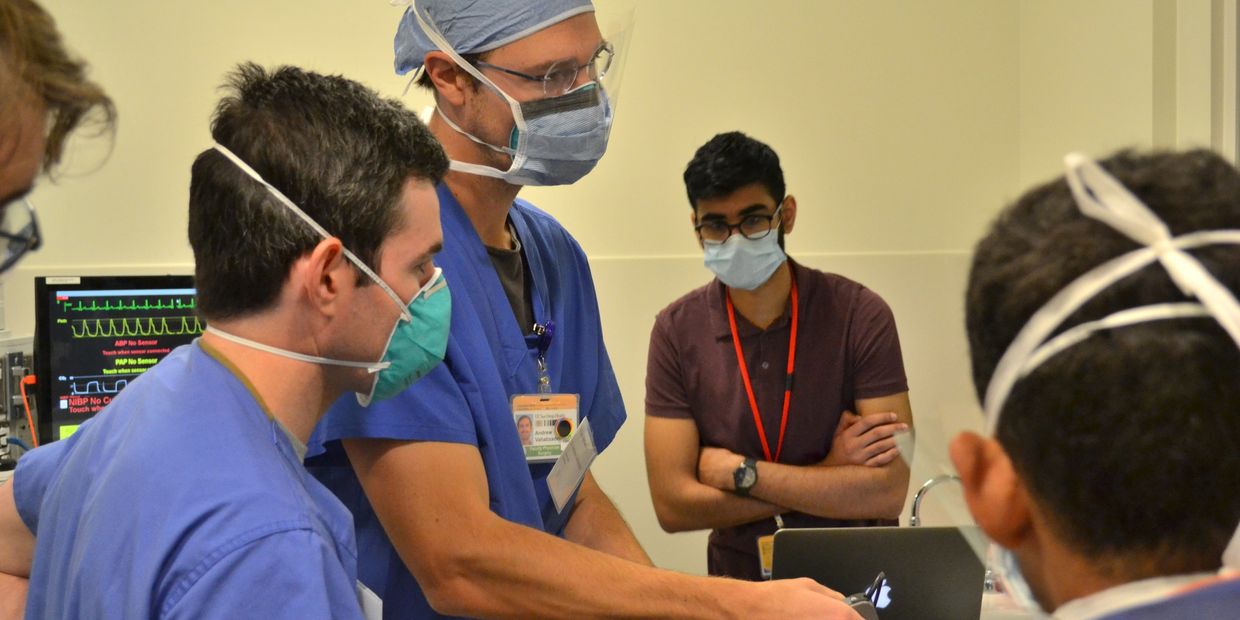 Medical professionals perform an intubation procedure in a clinical setting.
