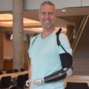 Darryl DuBre smiles brightly while wearing the ProHook  body-powered prosthetic terminal device.