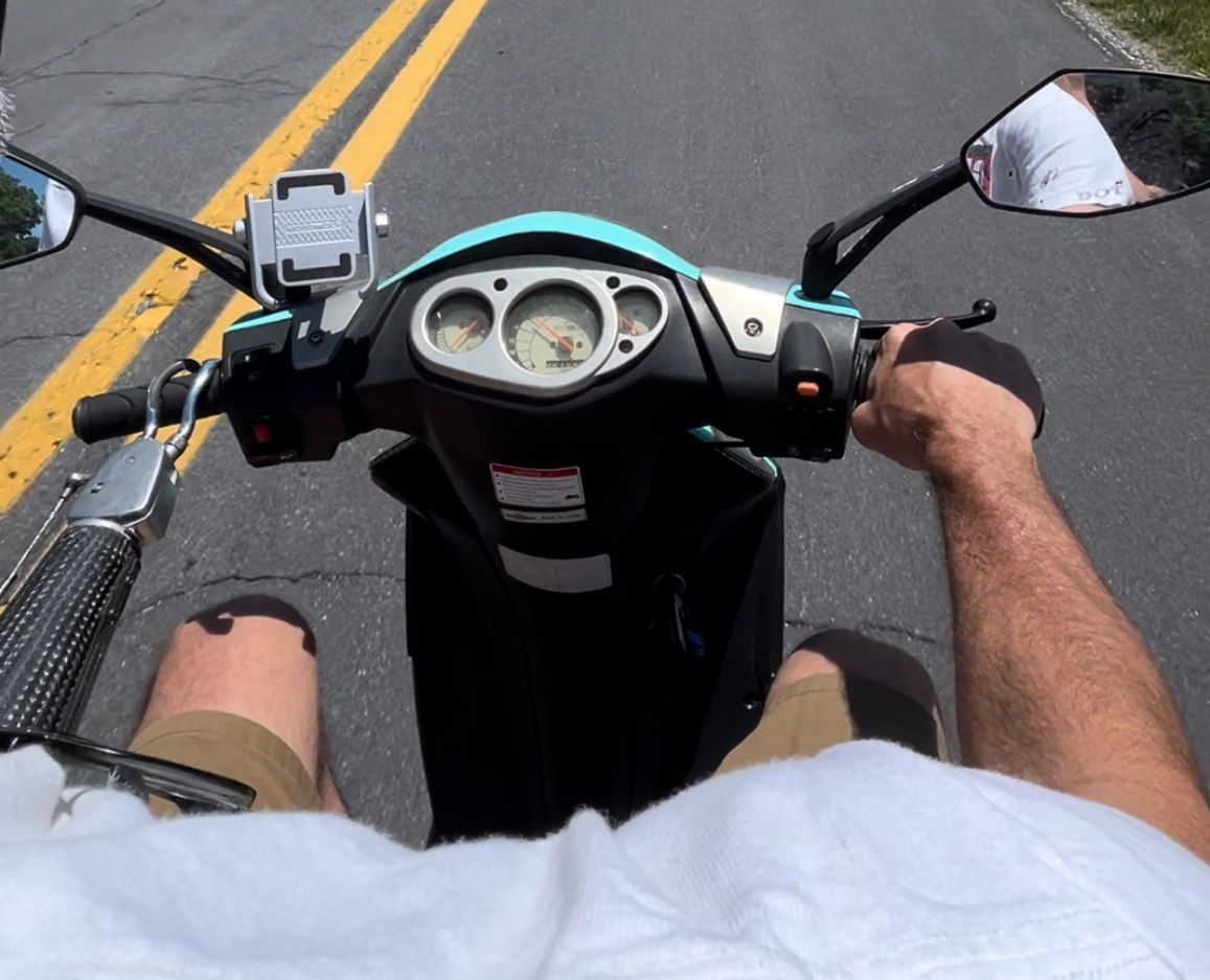 Upper-limb amputee driving scooter with prosthetic. Upper-limb amputee driving scooter with prosthetic.
