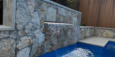 Concrete swimming pool sheer blade waterfall rock feature wall mistypools 