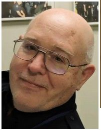 Smiling bald man with glasses.