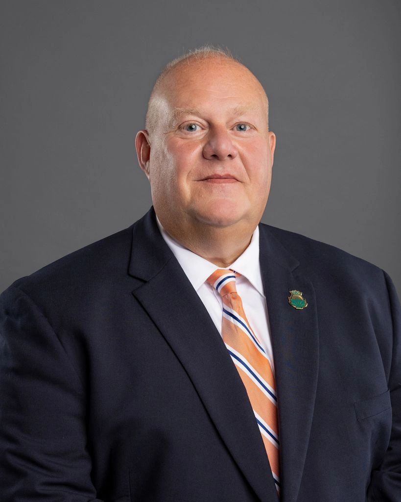 Portrait of a man in a suit and striped tie.