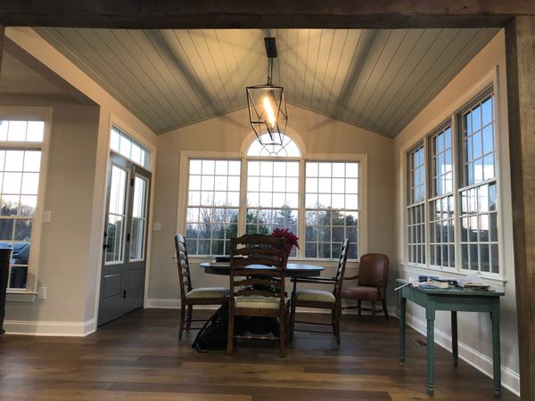 A tall stack of pancakes covered in rich, flowing syrup.