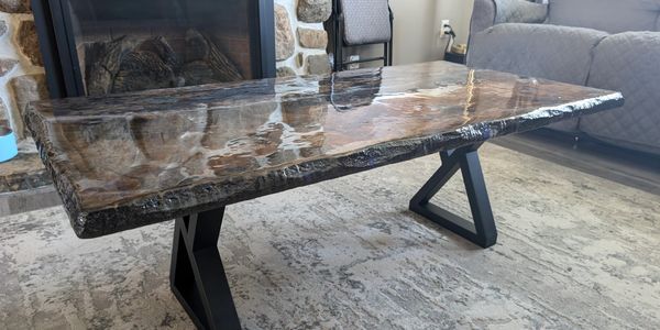 Glossy wooden coffee table with black metal legs in a cozy living room.