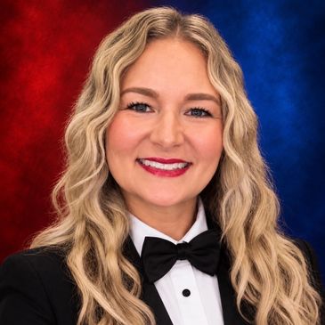 Smiling woman with long wavy blonde hair in formal attire and bow tie.