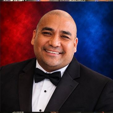 Man in tuxedo posing at USA Boxing event.