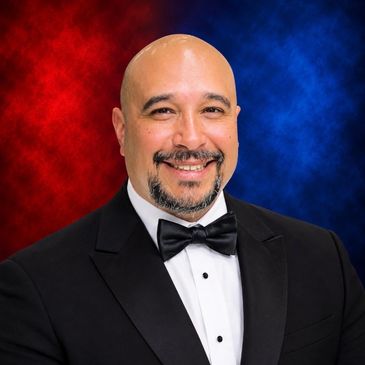 Man in tuxedo smiling at a USA Boxing and STABA event.