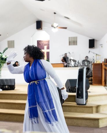 Woman dancing passionately in church service.