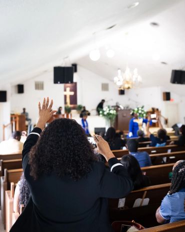Worshippers raising hands in church service.