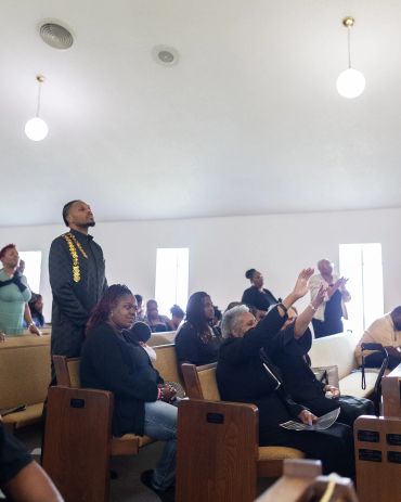 People worshipping in a church with raised hands.