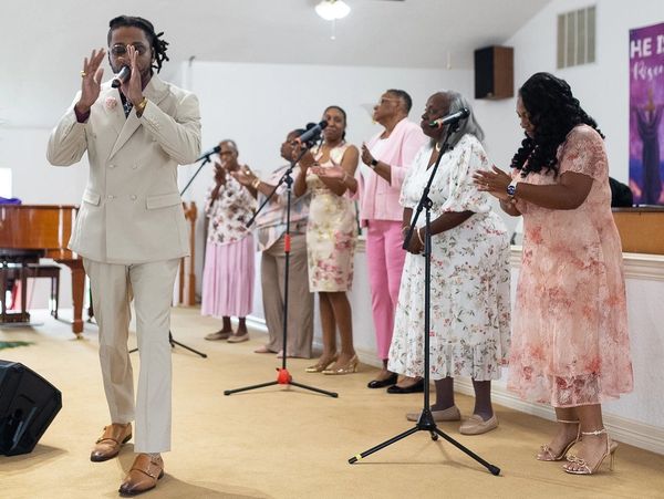 Group of people singing and clapping in a church.