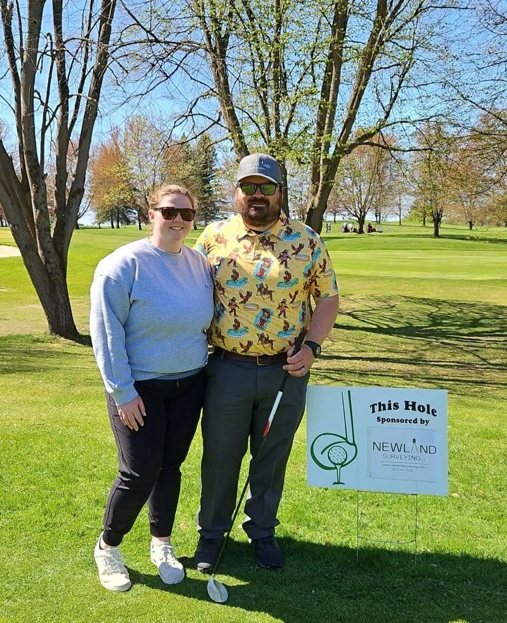 Andy and Taylor with golf outing sponsorship sign
