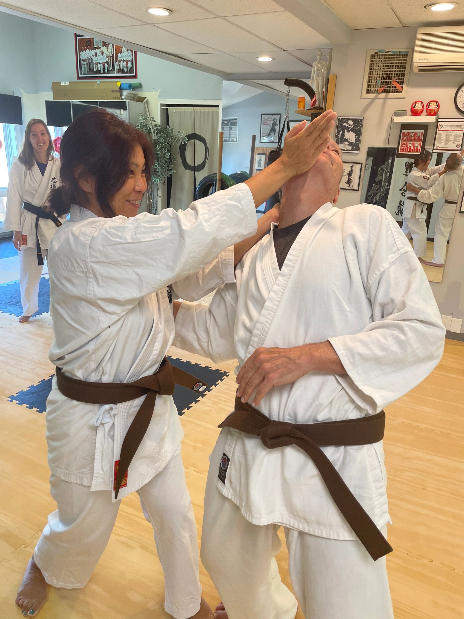 Adults practicing self-defense karate, demonstrating palm heel strike to chin. 