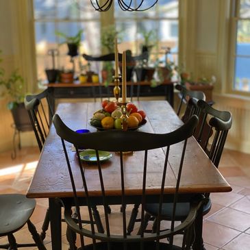 A dining table with a bowl of fruits and two candles