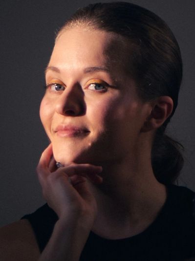 Portrait of a woman with a subtle smile and thoughtful expression.