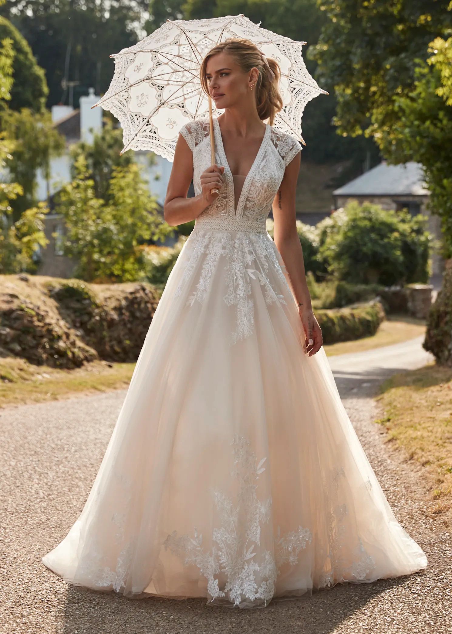 JW220929
A one of a kind tulle and lace A-line dress with a plunging neckline. Shown in Champagne