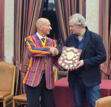 Two men shaking hands during an award presentation.