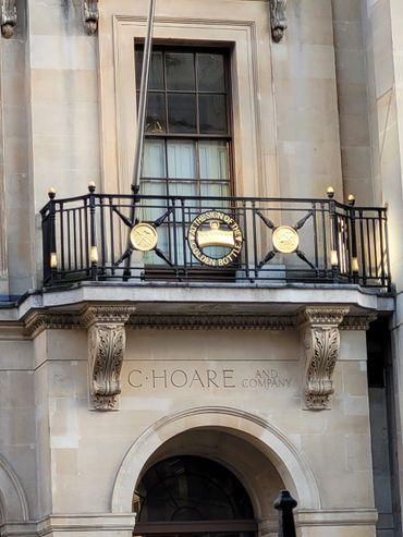 Historic building facade with ornate balcony and 'C Hoare and Company' inscription.