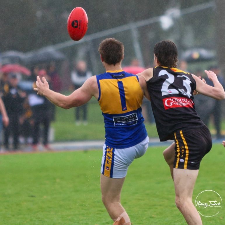 Two players competing for an airborne football during a game.