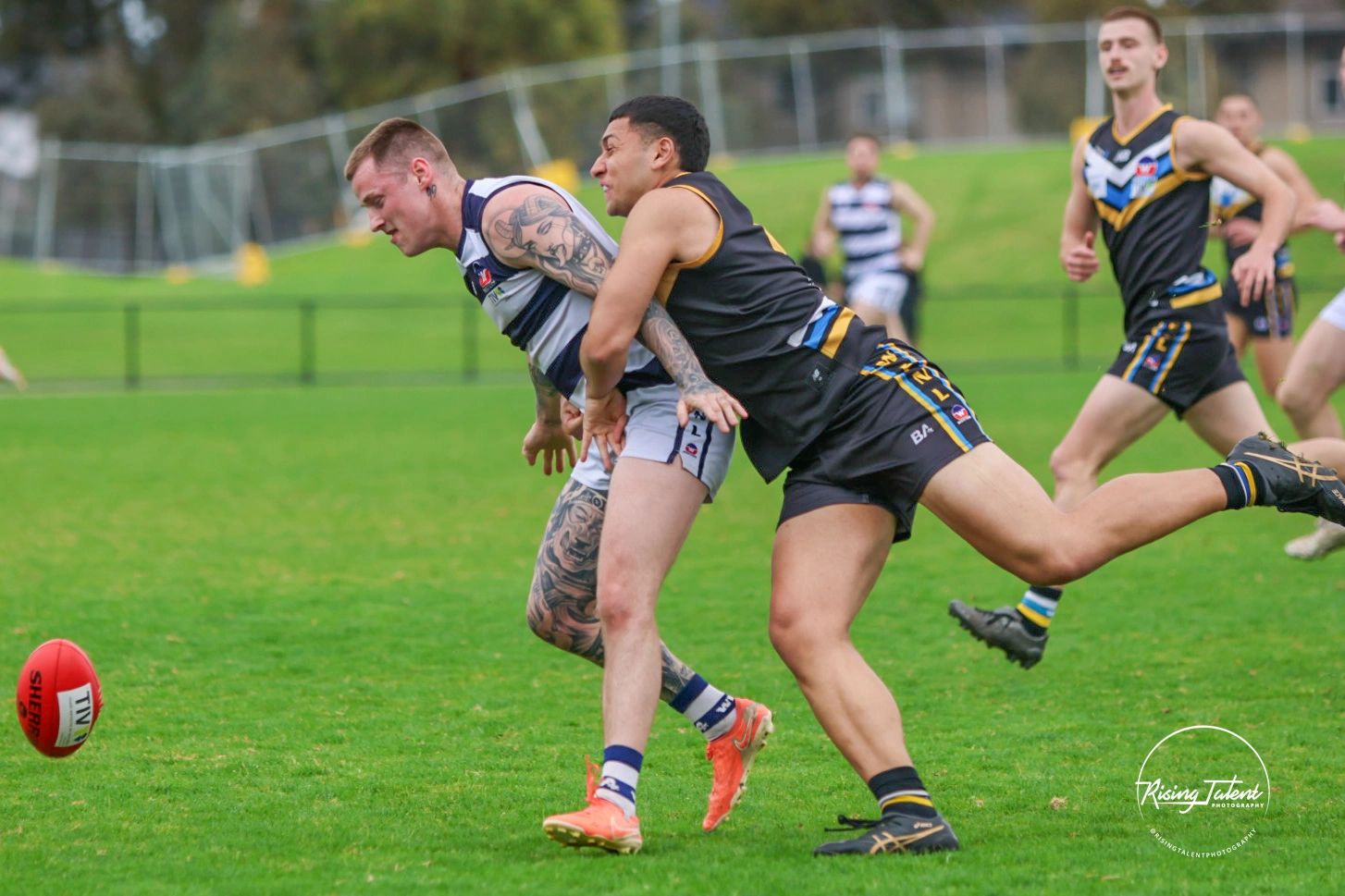Two Australian football players competing for the ball.