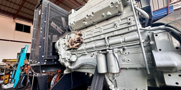 Large industrial engine inside a warehouse with various equipment.
